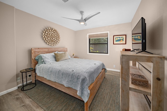 bedroom with a ceiling fan, baseboards, and wood finished floors