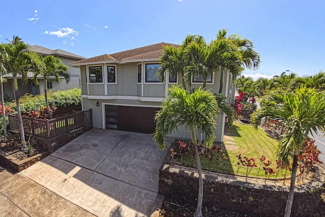 view of front facade featuring a front lawn, an attached garage, fence, and driveway