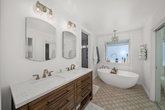 bathroom with a sink, a soaking tub, and double vanity