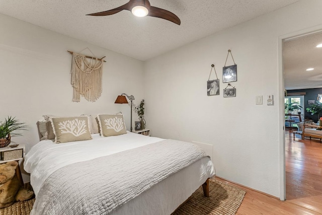 1299 Uluniu Rd Unit 103E, Kihei, HI 96753 - bedroom with wood finished floors, a textured ceiling, recessed lighting, ceiling fan, and baseboards