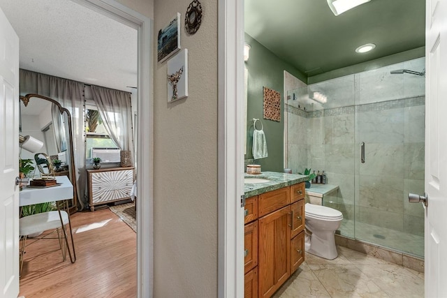 1299 Uluniu Rd Unit 103E, Kihei, HI 96753 - full bath featuring a shower stall, toilet, vanity, and wood finished floors