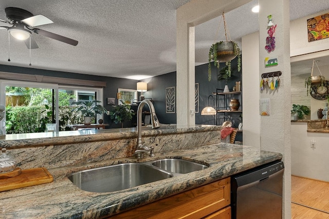 1299 Uluniu Rd Unit 103E, Kihei, HI 96753 - kitchen with dishwashing machine, a textured ceiling, a sink, wood finished floors, and dark stone countertops