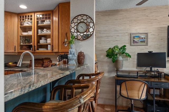 1299 Uluniu Rd Unit 103E, Kihei, HI 96753 - bar area featuring a textured ceiling, wood finished floors, and ceiling fan