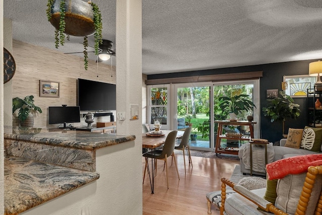 1299 Uluniu Rd Unit 103E, Kihei, HI 96753 - living room with a textured ceiling, wood finished floors, and ceiling fan