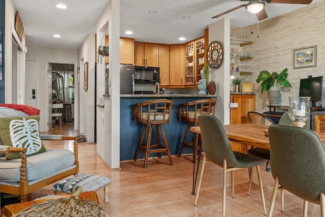 1299 Uluniu Rd Unit 103E, Kihei, HI 96753 - kitchen featuring black microwave, ceiling fan, glass insert cabinets, light wood-style flooring, and recessed lighting