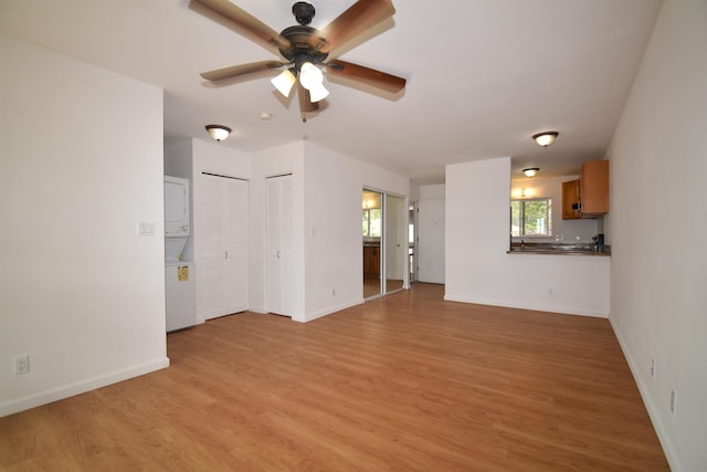 unfurnished living room with ceiling fan and light wood-type flooring