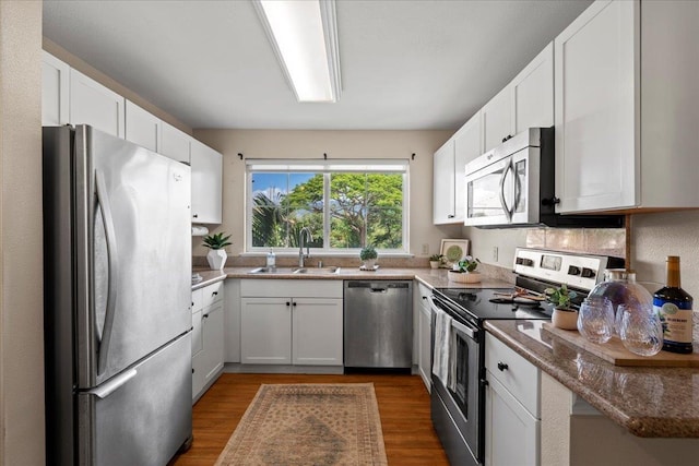 22 Kai Makani Loop Unit 201, Kihei, HI 96753 - kitchen with stainless steel appliances, a sink, dark wood finished floors, and white cabinetry