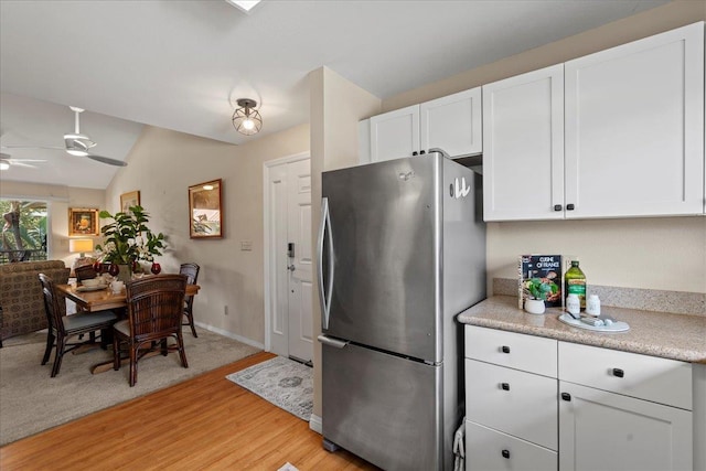 22 Kai Makani Loop Unit 201, Kihei, HI 96753 - kitchen with freestanding refrigerator, white cabinetry, a ceiling fan, light countertops, and vaulted ceiling