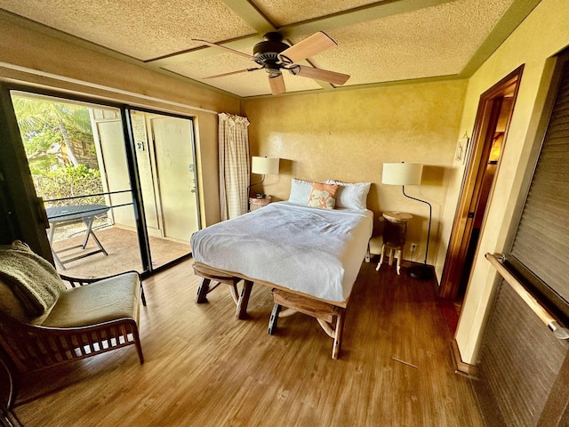 bedroom with ceiling fan, hardwood / wood-style floors, a textured ceiling, and access to outside