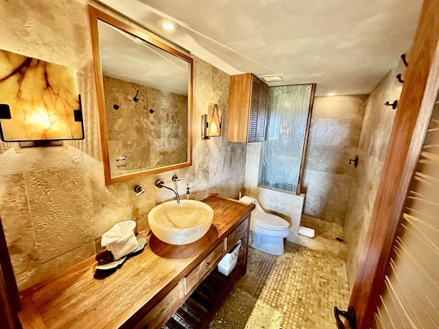 bathroom featuring tile walls, backsplash, vanity, toilet, and walk in shower