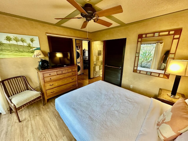 bedroom featuring a textured ceiling, ornamental molding, a closet, hardwood / wood-style flooring, and ceiling fan