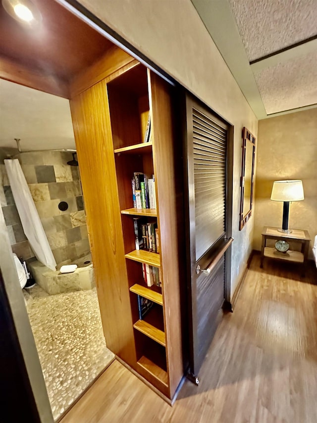 corridor featuring hardwood / wood-style flooring and a textured ceiling