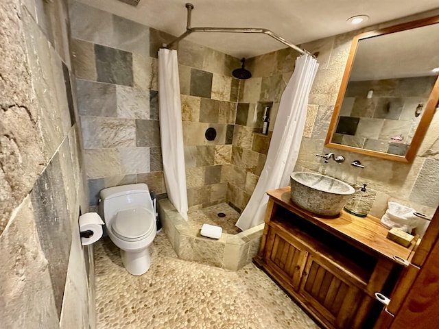 bathroom with vanity, toilet, tile walls, and a shower with curtain