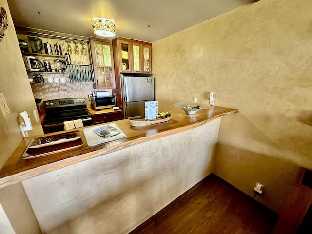 kitchen with appliances with stainless steel finishes, dark wood-type flooring, and kitchen peninsula