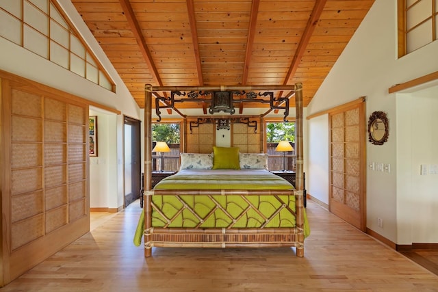 unfurnished bedroom featuring high vaulted ceiling, multiple windows, and light hardwood / wood-style flooring