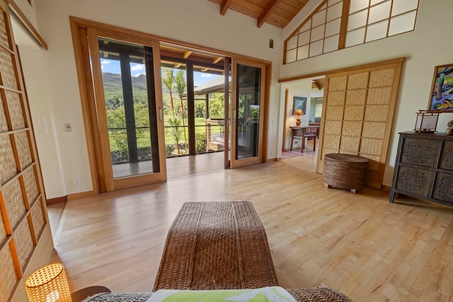 doorway featuring light wood-type flooring, beamed ceiling, high vaulted ceiling, french doors, and wood ceiling