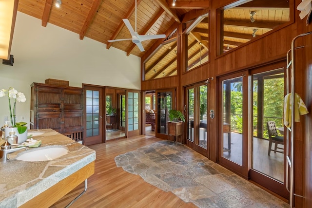 doorway with beam ceiling, sink, high vaulted ceiling, wooden ceiling, and hardwood / wood-style floors