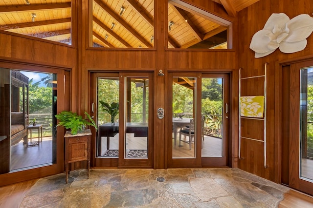 doorway to outside featuring wooden walls, beam ceiling, hardwood / wood-style floors, and wooden ceiling