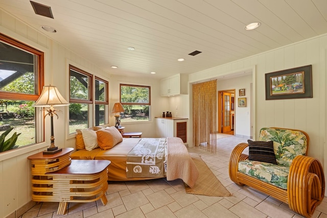 tiled bedroom featuring multiple windows and wood walls