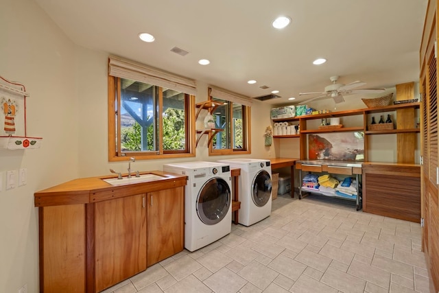 washroom featuring washing machine and dryer, ceiling fan, sink, and cabinets