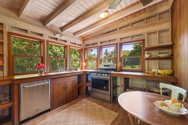 kitchen with sink, wooden ceiling, light hardwood / wood-style flooring, appliances with stainless steel finishes, and wood walls