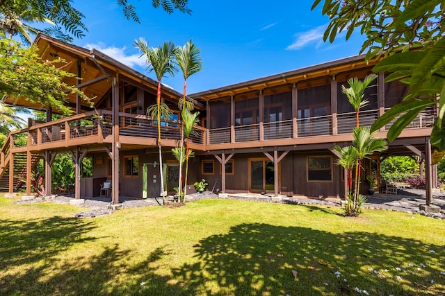 back of property with a lawn and a patio