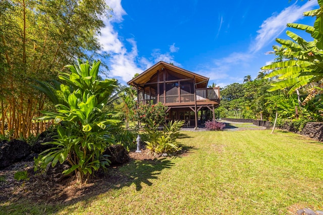 back of property featuring a sunroom and a lawn