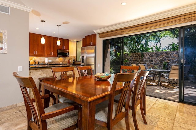 dining space featuring crown molding