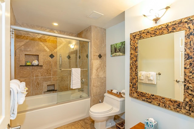 bathroom featuring tile patterned flooring, toilet, and shower / bath combination with glass door