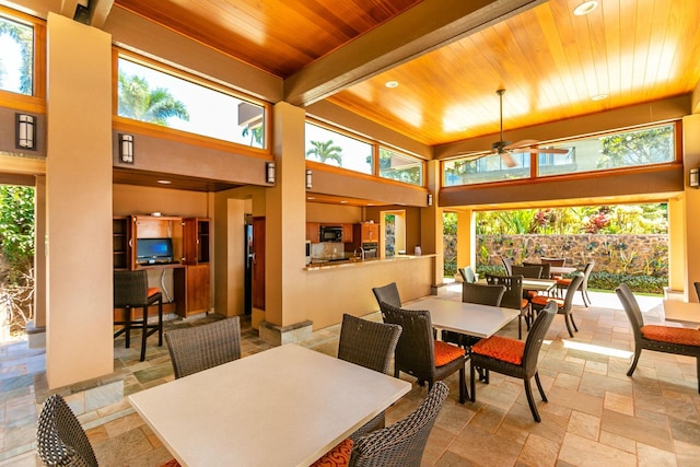 dining area with beamed ceiling, plenty of natural light, ceiling fan, and wood ceiling