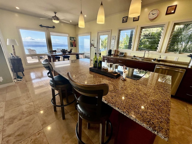 bar featuring pendant lighting, sink, light tile patterned floors, dishwasher, and a water view