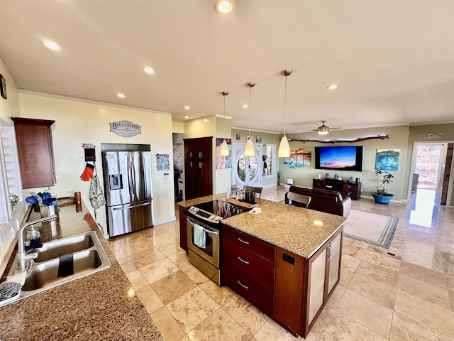 kitchen with a kitchen island, appliances with stainless steel finishes, decorative light fixtures, sink, and light stone counters