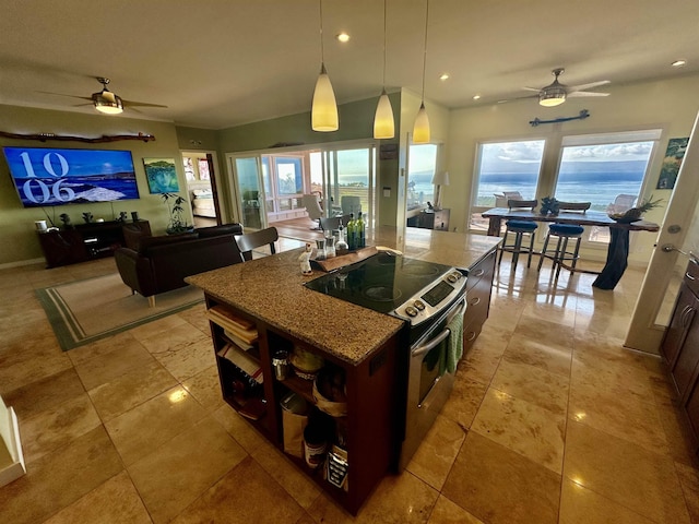 kitchen with stainless steel electric range, stone counters, hanging light fixtures, a healthy amount of sunlight, and a kitchen island