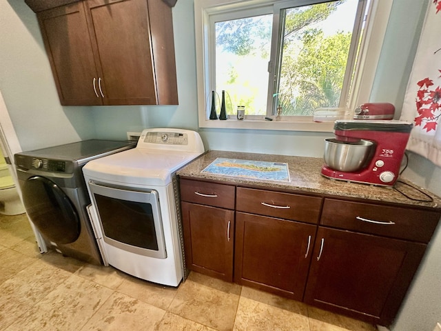 laundry room featuring cabinets and washer and clothes dryer