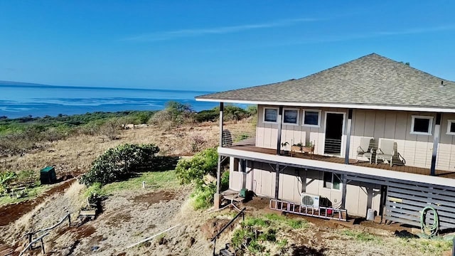 rear view of house with a balcony and a water view