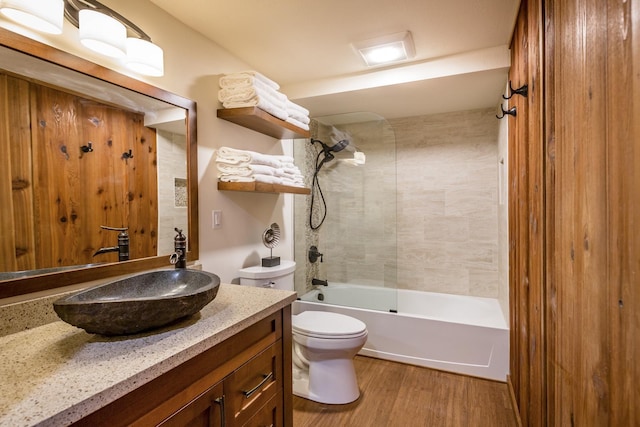 full bathroom with toilet, hardwood / wood-style floors, vanity, and tiled shower / bath