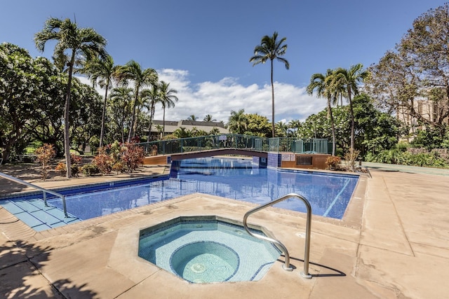 view of swimming pool featuring an in ground hot tub and a patio