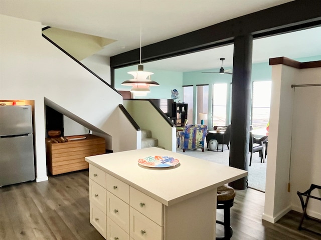 kitchen featuring dark wood-type flooring, ceiling fan, decorative light fixtures, and stainless steel refrigerator