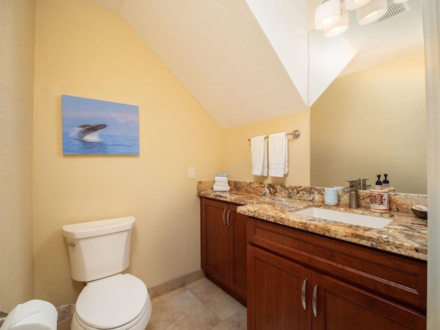 bathroom featuring tile patterned floors, vanity, vaulted ceiling, and toilet