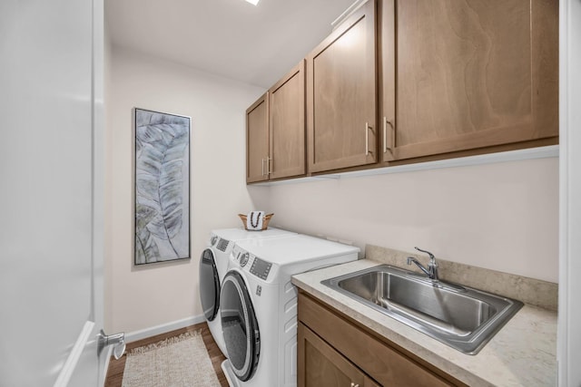 washroom with washer and dryer, cabinet space, baseboards, and wood finished floors