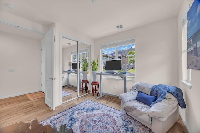sitting room with wood finished floors, healthy amount of natural light, and baseboards