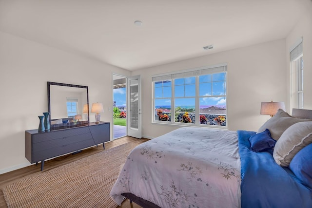bedroom with access to exterior, wood finished floors, and baseboards