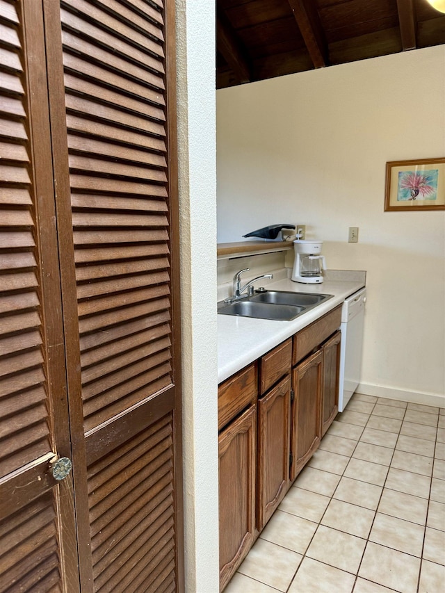 kitchen with sink, wooden ceiling, beamed ceiling, white dishwasher, and light tile patterned floors