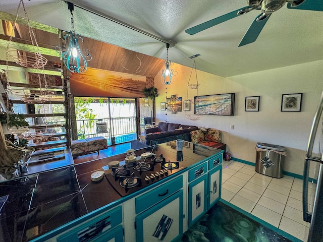 kitchen with lofted ceiling, ceiling fan, tile patterned flooring, and a textured ceiling