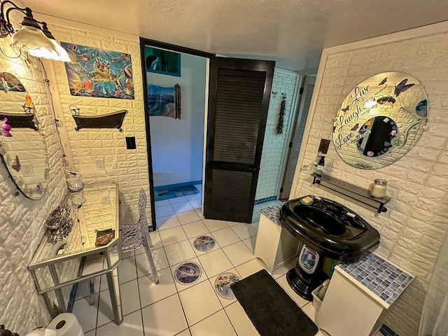 bathroom featuring tile patterned flooring and a textured ceiling