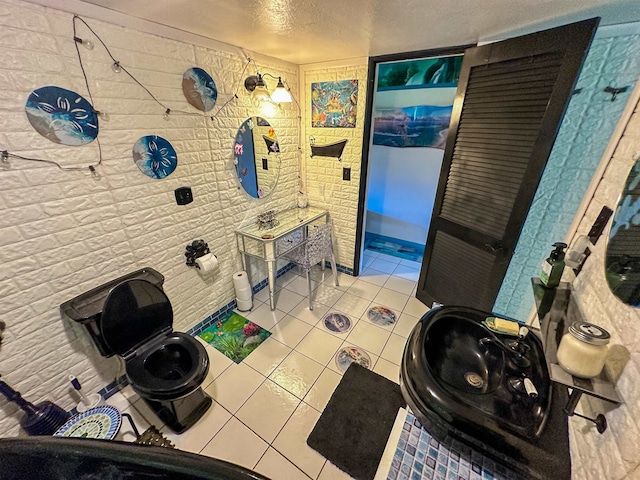 bathroom featuring tile patterned flooring, toilet, and a textured ceiling