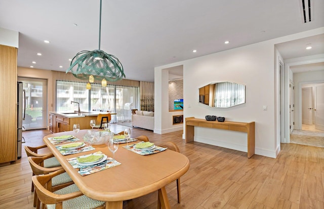 dining space with light hardwood / wood-style floors and sink