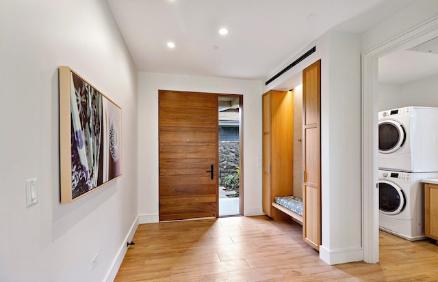 interior space featuring stacked washing maching and dryer and light hardwood / wood-style floors