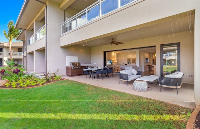 exterior space with an outdoor kitchen, a patio area, ceiling fan, and a lawn