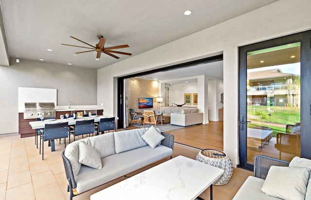 living room featuring ceiling fan and light tile patterned floors